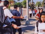 Students handing out fliers across from a high school.